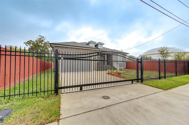 view of gate with a yard and a garage