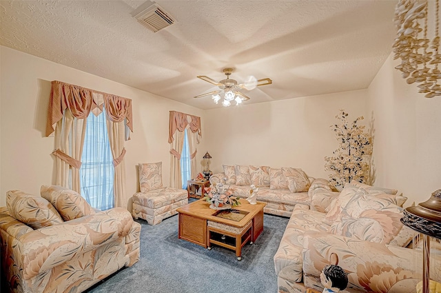 carpeted living room featuring ceiling fan and a textured ceiling