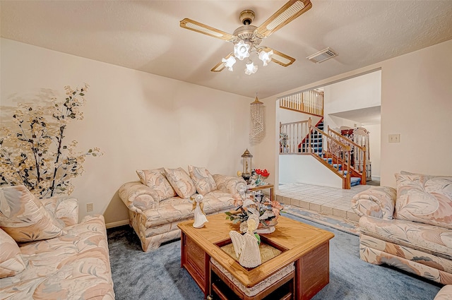 living room with ceiling fan, dark carpet, and a textured ceiling