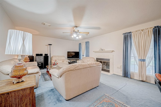 carpeted living room with a textured ceiling and ceiling fan