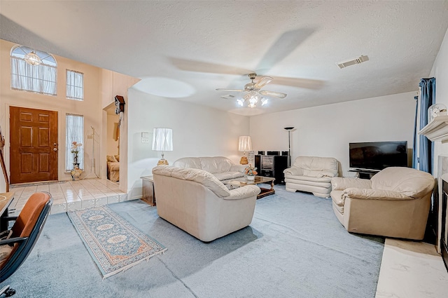 living room with ceiling fan and a textured ceiling