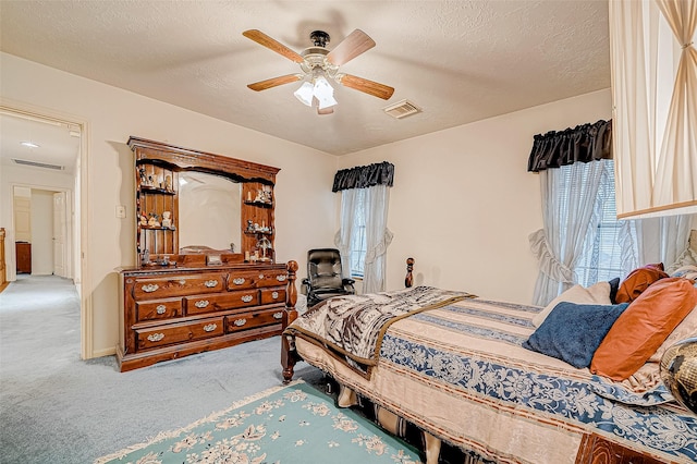 carpeted bedroom with a textured ceiling and ceiling fan