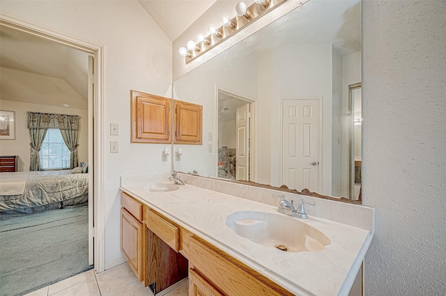 bathroom featuring tile patterned flooring, a textured ceiling, vanity, and vaulted ceiling