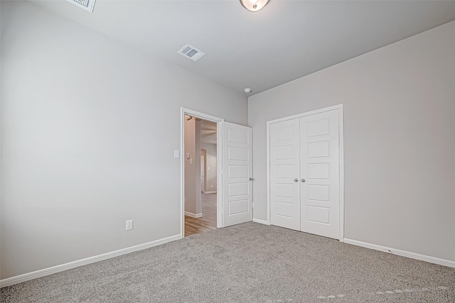 unfurnished bedroom featuring carpet flooring and a closet