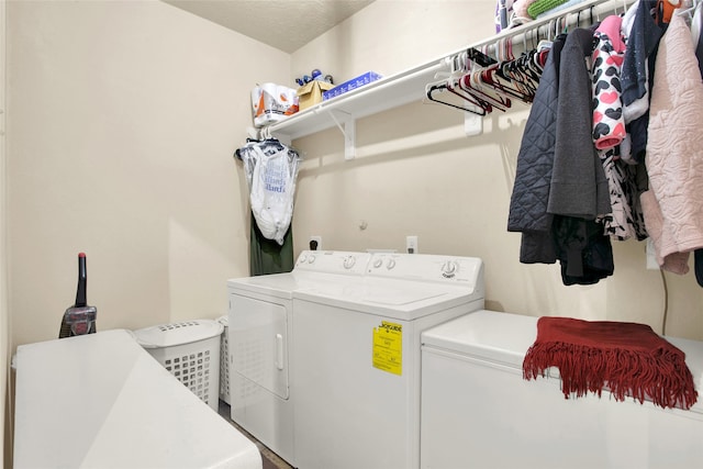 laundry area featuring a textured ceiling and washer and clothes dryer