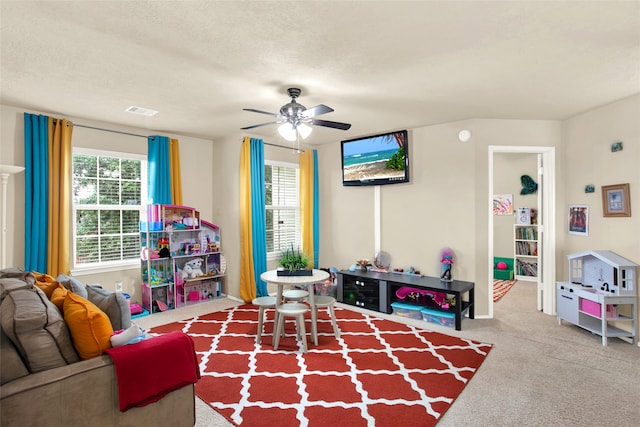 recreation room with ceiling fan, carpet, and a textured ceiling