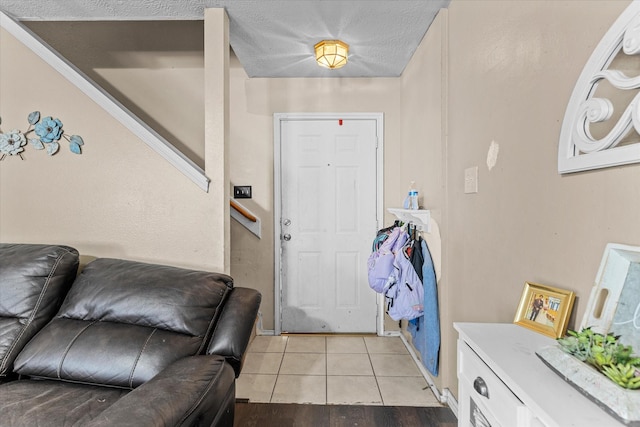 tiled entryway featuring a textured ceiling