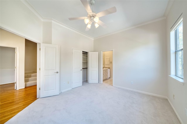 carpeted bedroom featuring ceiling fan, crown molding, and ensuite bathroom