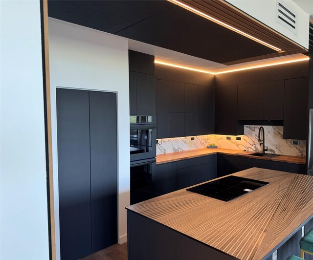 kitchen with dark wood-type flooring, sink, and black appliances