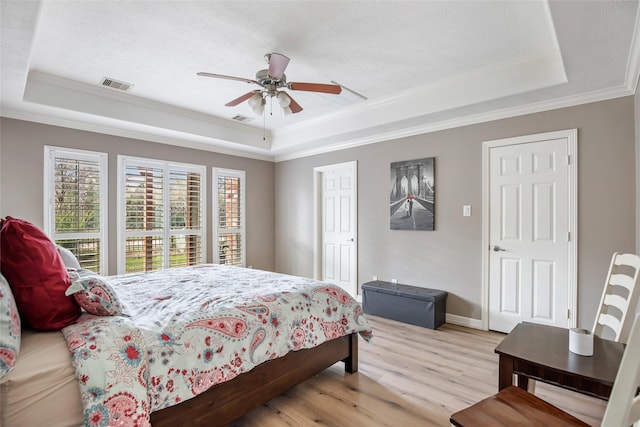 bedroom featuring ceiling fan, ornamental molding, and a tray ceiling