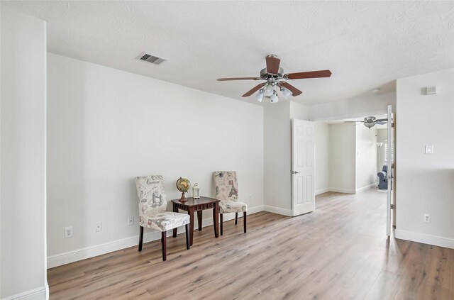 sitting room with a textured ceiling and light hardwood / wood-style floors