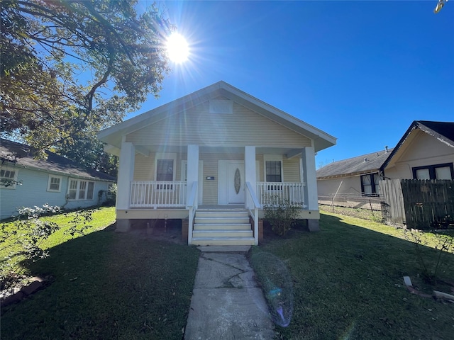 bungalow-style house with a porch and a front lawn