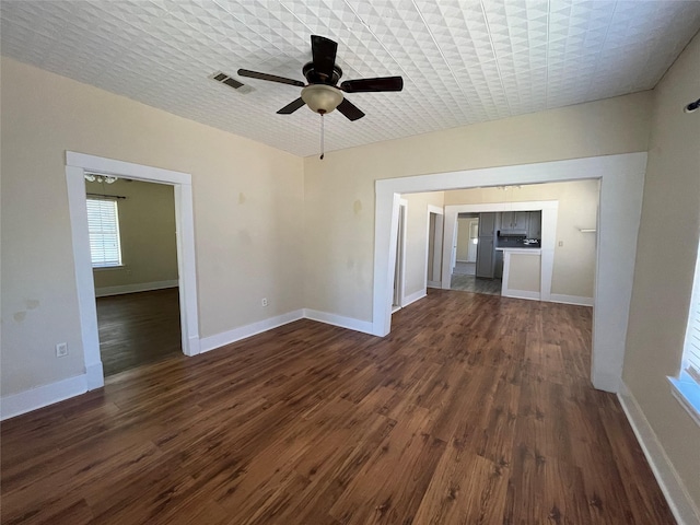 unfurnished living room with dark hardwood / wood-style flooring and ceiling fan