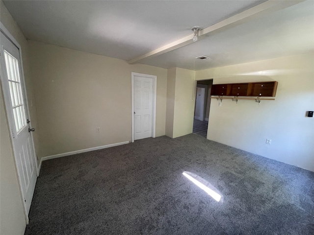 carpeted empty room with beamed ceiling