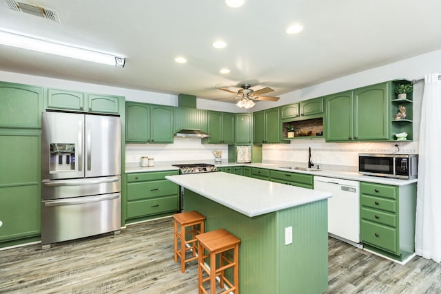 kitchen featuring a center island, sink, green cabinetry, ceiling fan, and stainless steel appliances