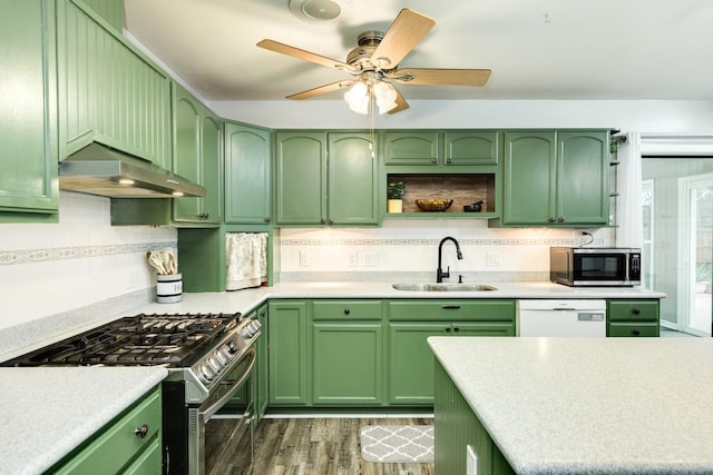 kitchen featuring range hood, sink, appliances with stainless steel finishes, and green cabinetry