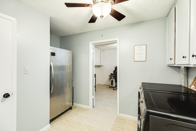 kitchen with a textured ceiling, washing machine and dryer, white cabinetry, range with electric stovetop, and stainless steel refrigerator