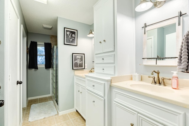 bathroom featuring tile patterned flooring, a textured ceiling, vanity, and a shower with shower door