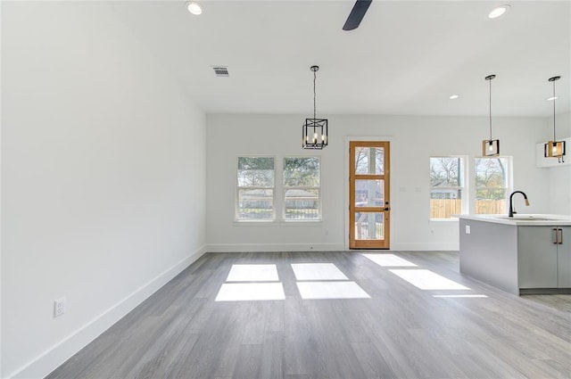 interior space featuring sink, ceiling fan with notable chandelier, and light hardwood / wood-style flooring