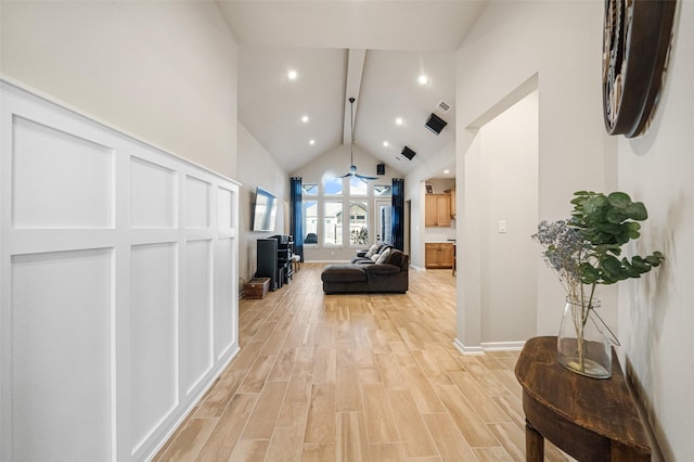 hall with light wood-type flooring and high vaulted ceiling