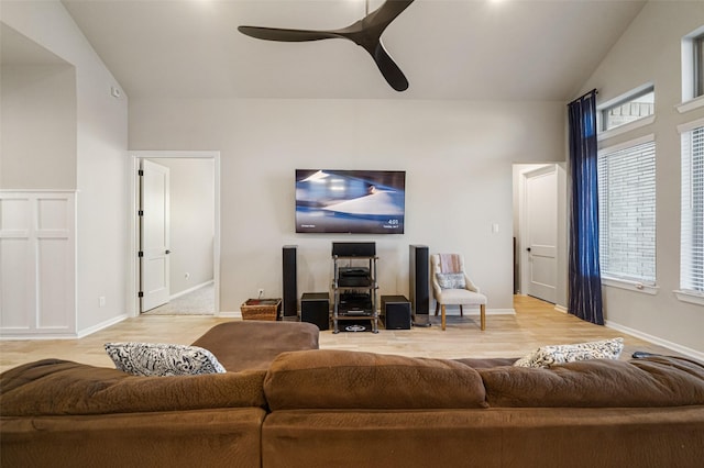 living room with hardwood / wood-style flooring, ceiling fan, and vaulted ceiling