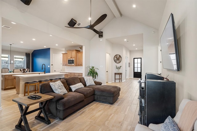 living room with beam ceiling, high vaulted ceiling, and ceiling fan