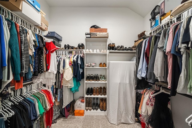 spacious closet with carpet flooring and vaulted ceiling