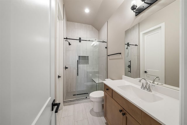 bathroom featuring lofted ceiling, vanity, an enclosed shower, and toilet