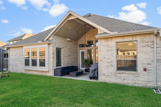 rear view of house featuring a yard, an outdoor living space, a trampoline, and a patio