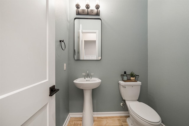 bathroom featuring hardwood / wood-style floors and toilet