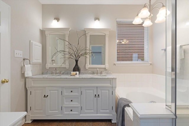 bathroom featuring a tub to relax in, vanity, and an inviting chandelier