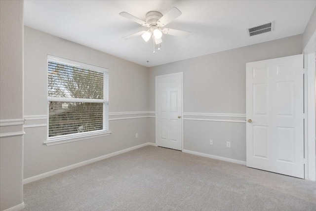 carpeted spare room with ceiling fan