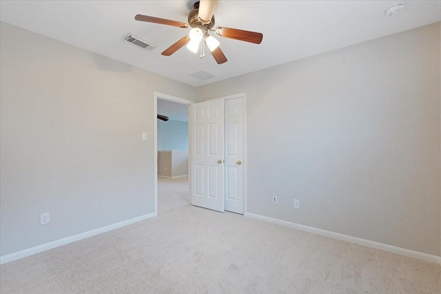 carpeted spare room featuring ceiling fan