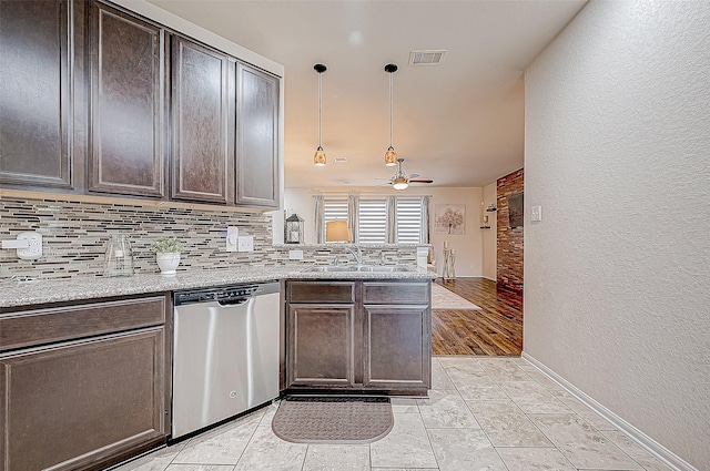 kitchen featuring kitchen peninsula, stainless steel dishwasher, dark brown cabinets, sink, and hanging light fixtures