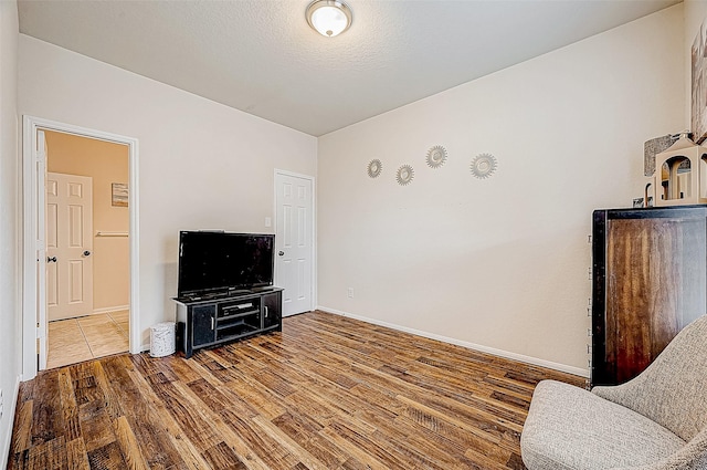 sitting room with hardwood / wood-style flooring and a textured ceiling