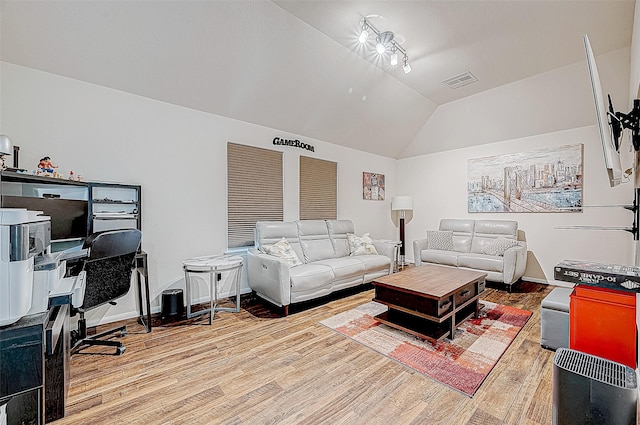 living room featuring wood-type flooring, rail lighting, and vaulted ceiling