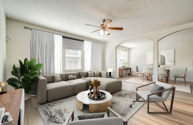 living room with ceiling fan and light wood-type flooring