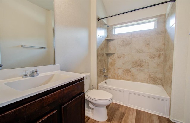 full bathroom with vanity, tiled shower / bath combo, hardwood / wood-style flooring, and toilet