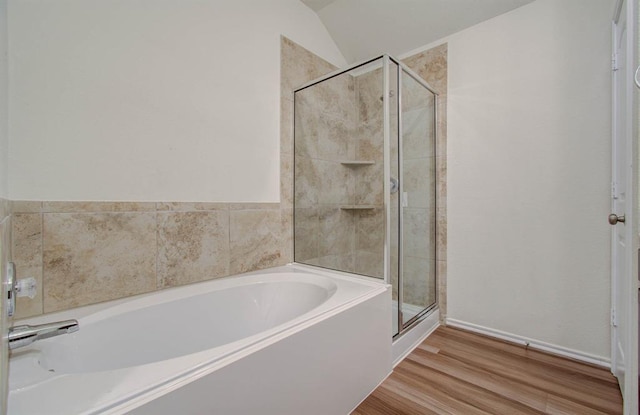 bathroom featuring plus walk in shower, wood-type flooring, and lofted ceiling