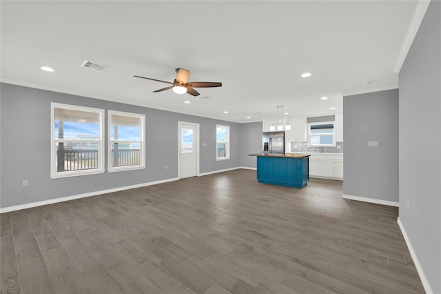 unfurnished living room featuring dark hardwood / wood-style flooring, plenty of natural light, and ceiling fan