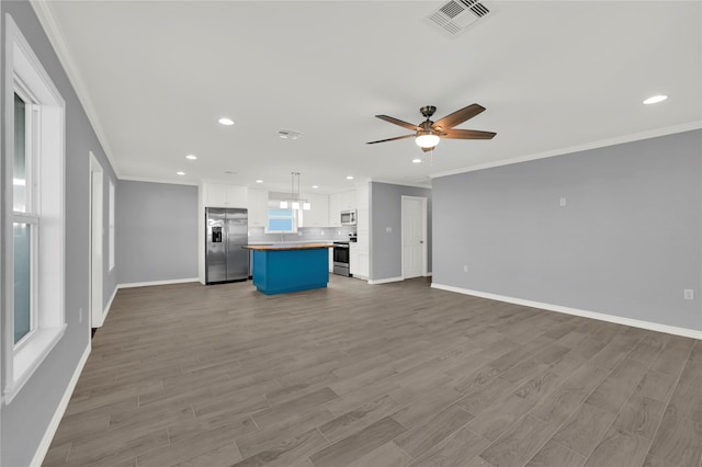 unfurnished living room featuring ceiling fan, crown molding, and light hardwood / wood-style flooring