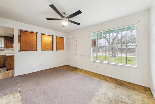 spare room featuring ceiling fan and light colored carpet