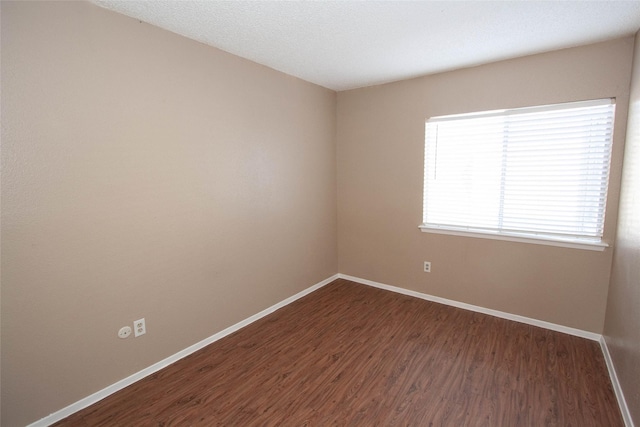 spare room with dark wood-type flooring