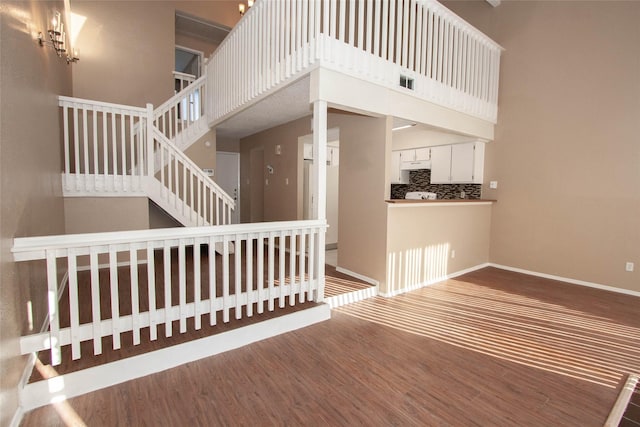 stairs featuring hardwood / wood-style floors and a towering ceiling