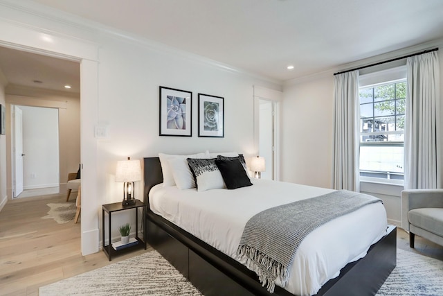 bedroom featuring light hardwood / wood-style floors and crown molding