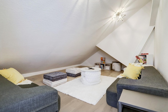 living room with light wood-type flooring and vaulted ceiling