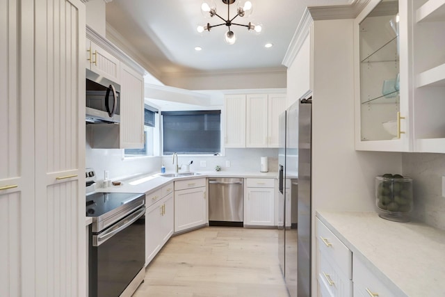 kitchen with white cabinets, sink, a notable chandelier, light hardwood / wood-style floors, and stainless steel appliances