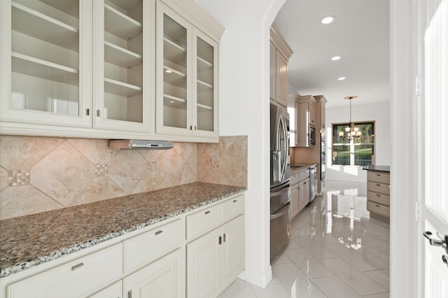 kitchen featuring dark stone counters, an inviting chandelier, decorative backsplash, decorative light fixtures, and stainless steel fridge with ice dispenser