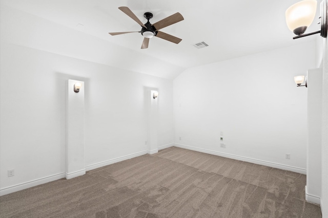 empty room featuring ceiling fan, carpet floors, and vaulted ceiling