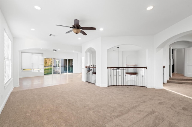 unfurnished living room with light carpet and ceiling fan